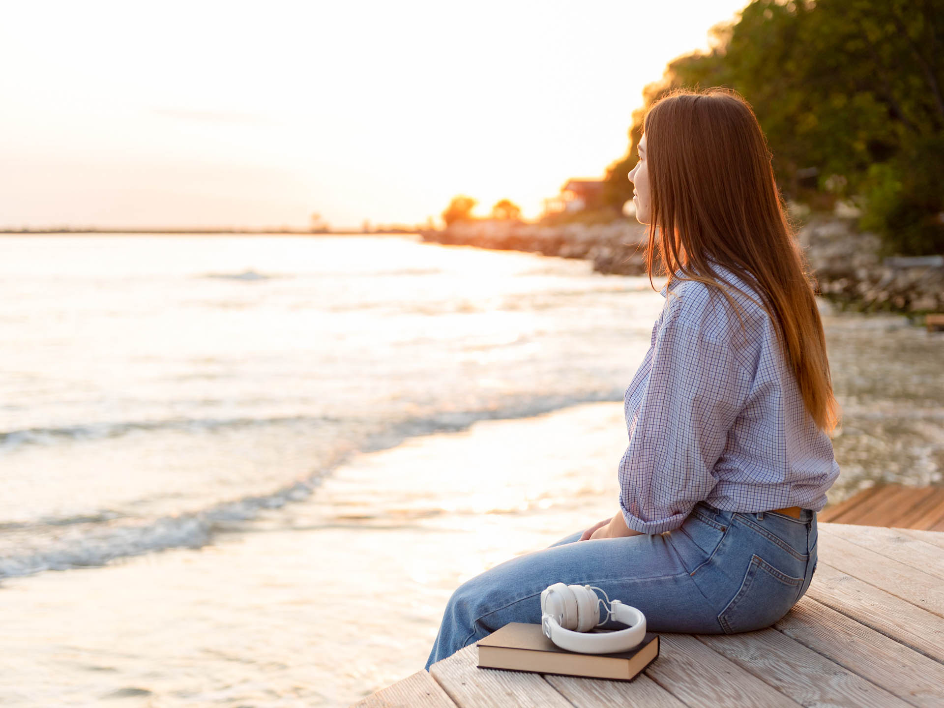 kobieta-siedzaca-na-pomoscie-i-ogladajaca-wschod-slonca