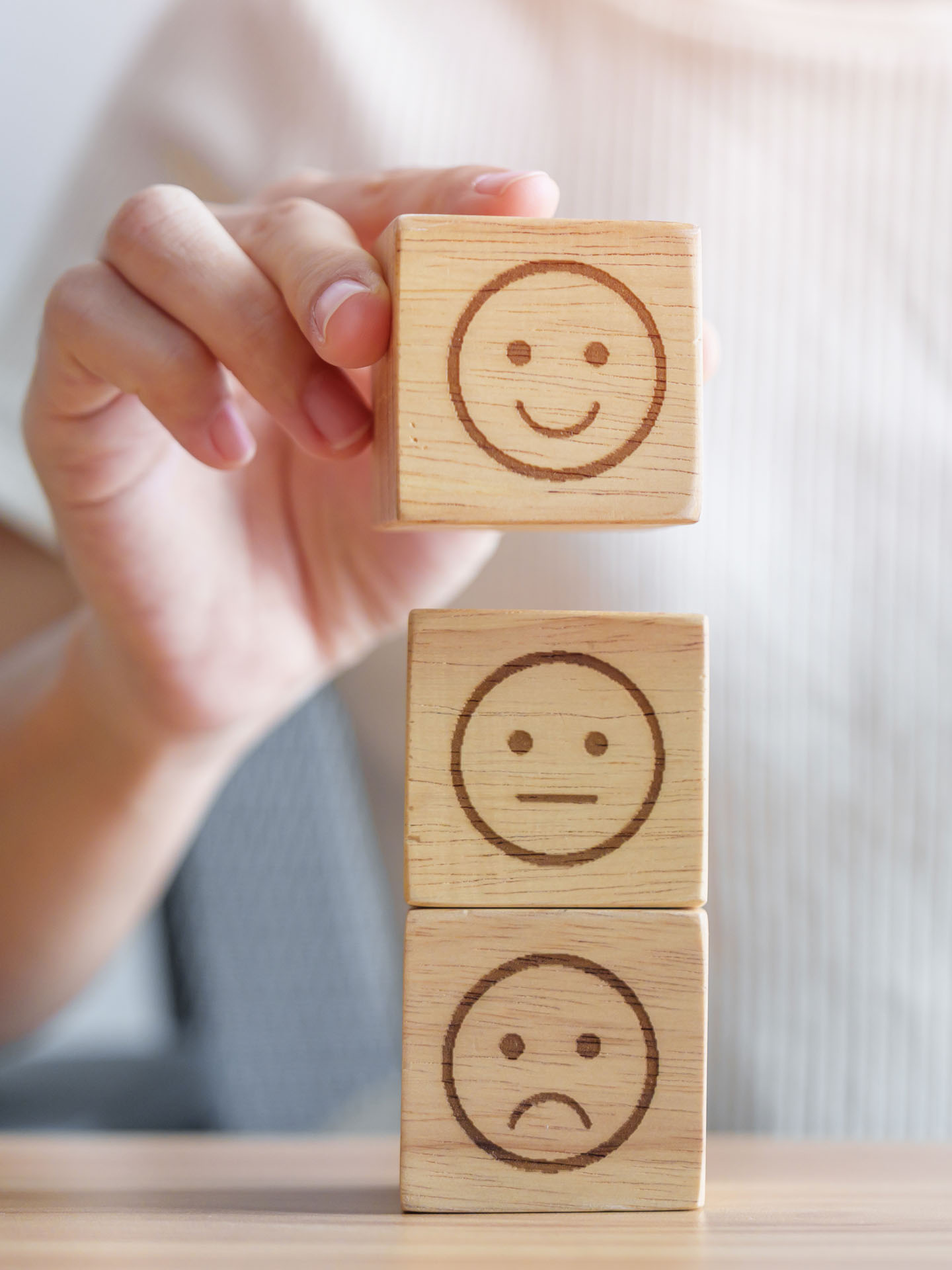 trzy-drewniane-klocki-ukladane-przez-kobiete